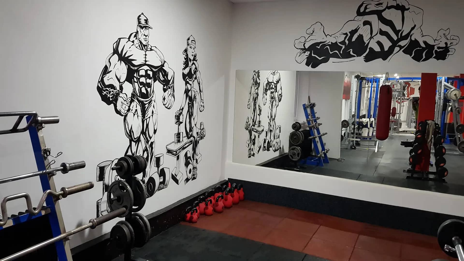 Zrkadlová stena s činkami a kettlebellmi