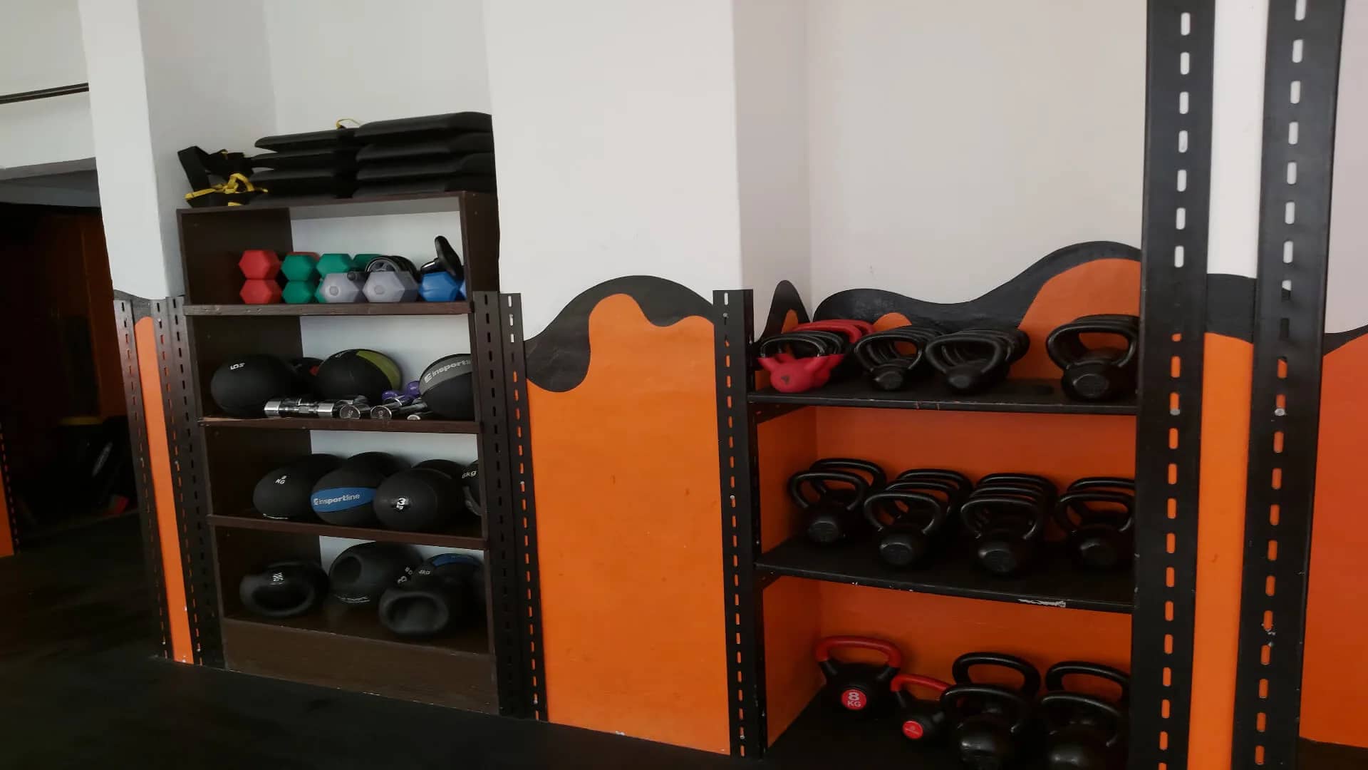 Regál s medicinbalmi a kettlebellmi